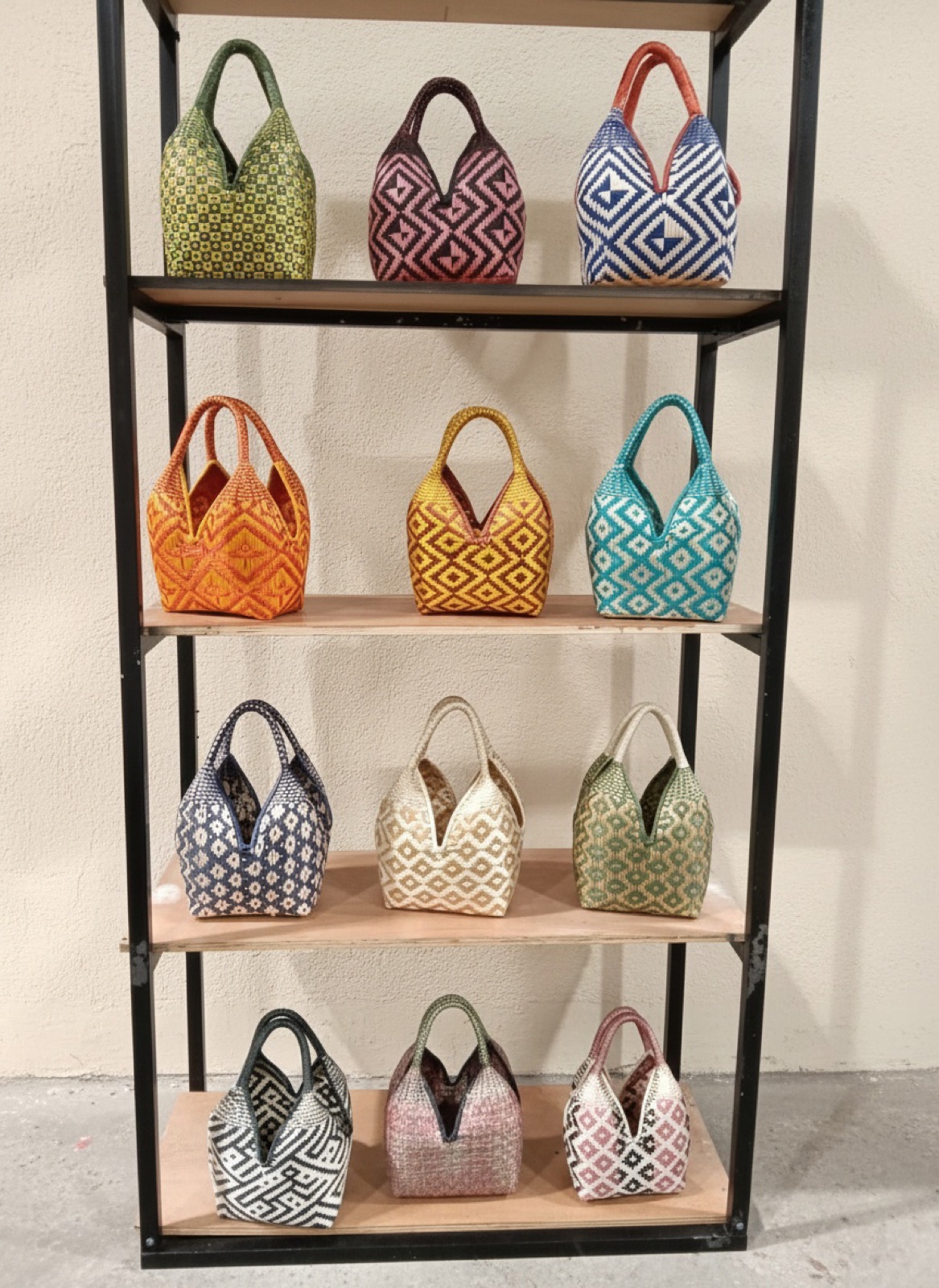 Shelf of hand-woven mini bags in twelve colorways